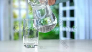 从厨房桌上的水壶中，近距离倒入纯净的新鲜饮用水